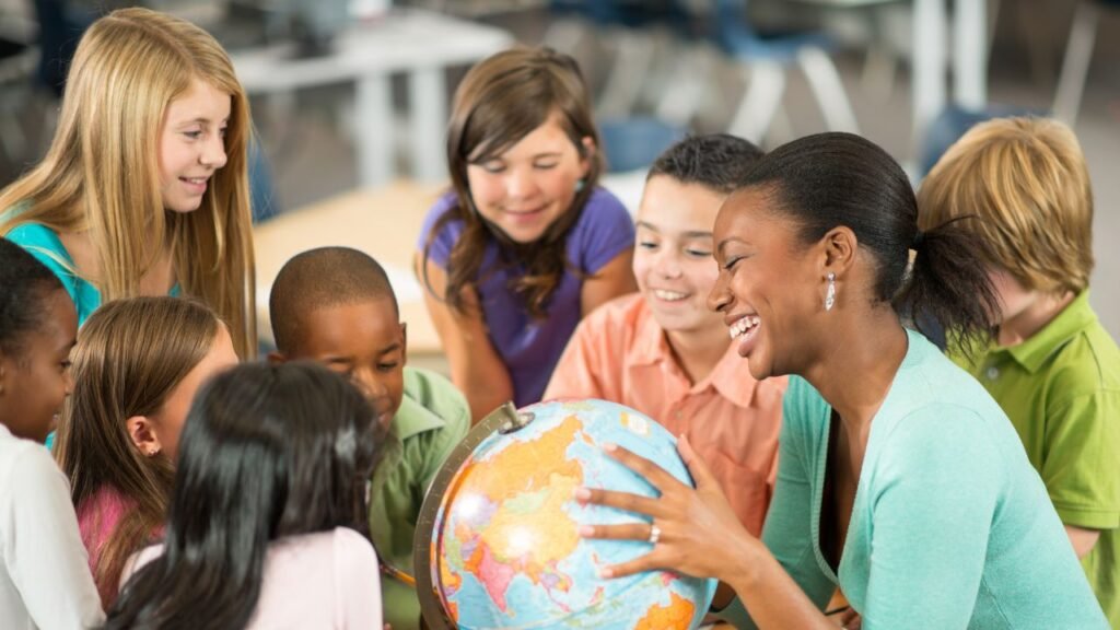 Licenciatura em Geografia Estácio: Vale a Pena? Análise Completa 2026 2 sala de aula com trabalho em grupo auxiliado pela professora de Geografia